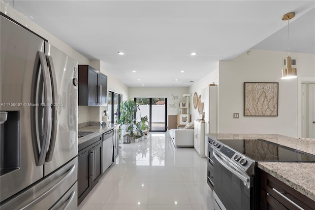 kitchen with light stone counters, dark brown cabinetry, recessed lighting, stainless steel appliances, and pendant lighting