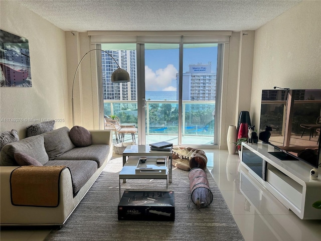 living area featuring a textured ceiling, a textured wall, tile patterned flooring, and floor to ceiling windows