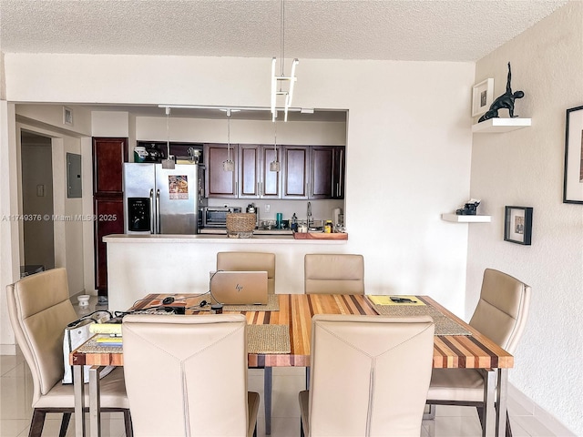 dining room with a toaster, electric panel, and a textured ceiling