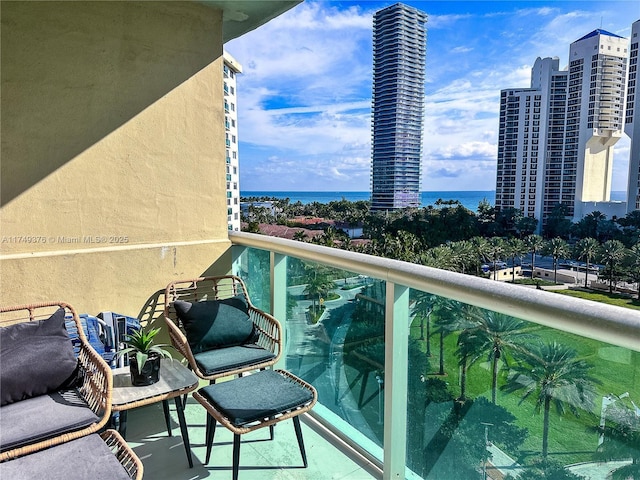 balcony featuring a water view and a city view