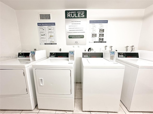 community laundry room featuring light tile patterned floors and washer and clothes dryer