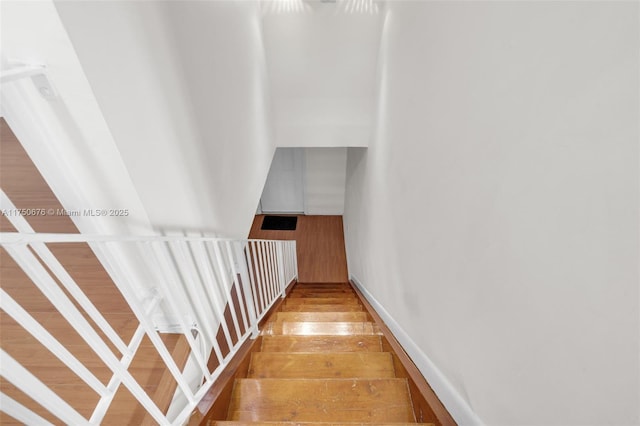 stairs featuring wood finished floors and baseboards