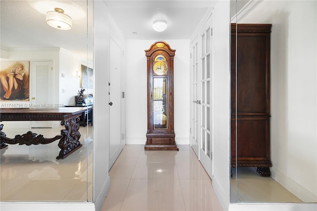 interior space with light tile patterned flooring, crown molding, and baseboards