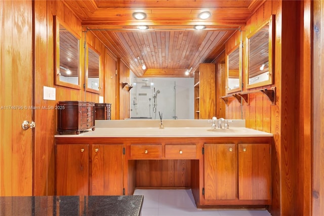 bathroom with a stall shower, wooden ceiling, wooden walls, and vanity