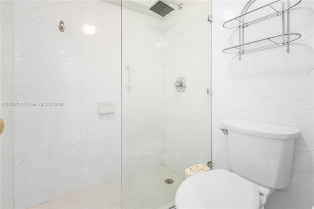 bathroom featuring tile walls, toilet, and a walk in shower