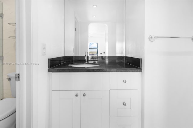 bathroom featuring vanity, toilet, and an enclosed shower