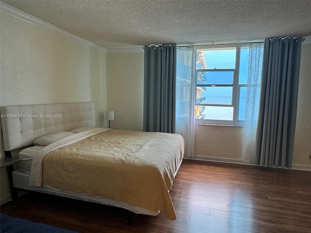 bedroom with crown molding, a textured ceiling, and wood finished floors