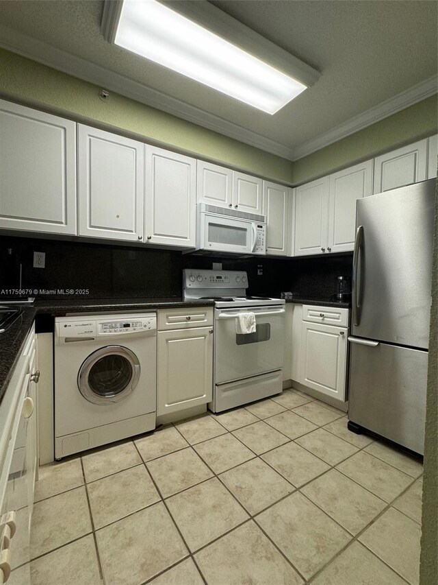 kitchen with dark countertops, ornamental molding, white cabinets, washer / dryer, and white appliances