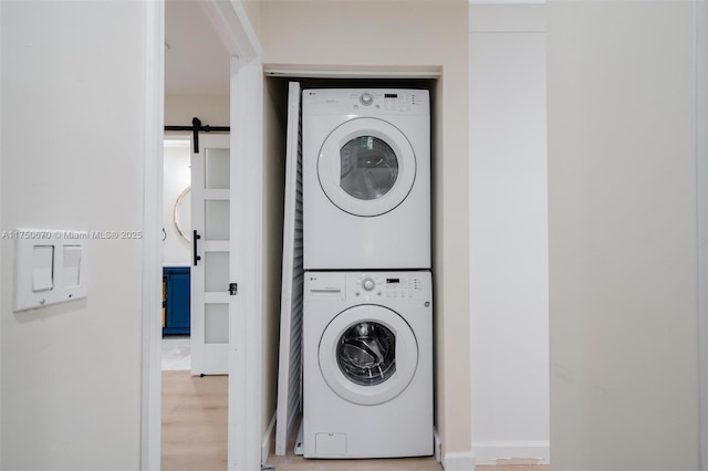 17329 Birchwood Ln Unit A, Fort Myers, FL 33908 - laundry room with laundry area, a barn door, stacked washing maching and dryer, and light wood-type flooring