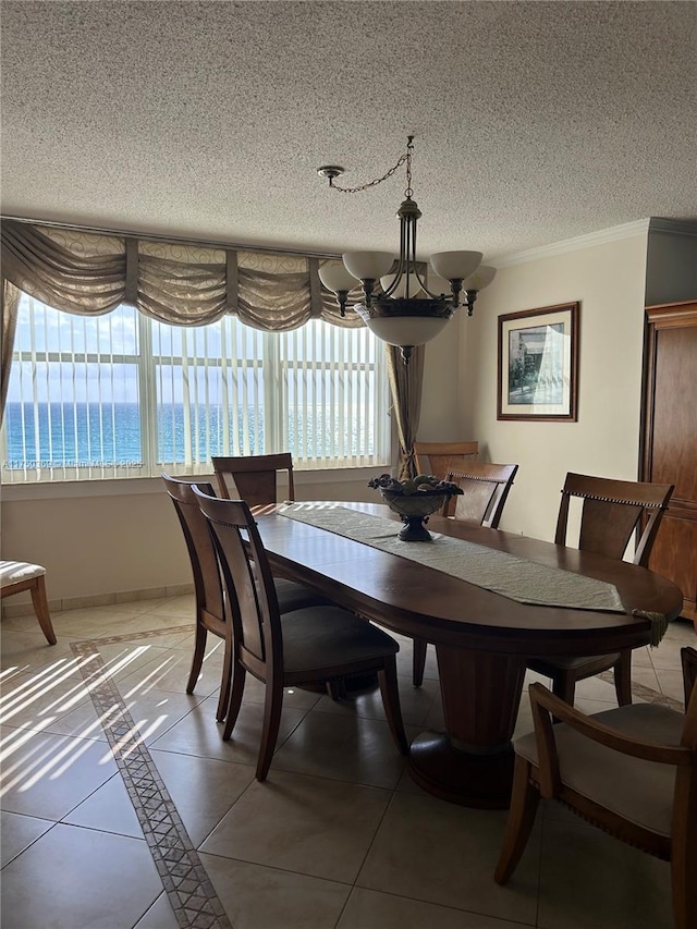 dining space featuring light tile patterned floors, ornamental molding, a textured ceiling, a chandelier, and baseboards