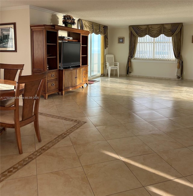 living room with crown molding, a textured ceiling, baseboards, and light tile patterned floors