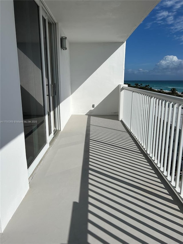 balcony featuring a water view and a view of the beach