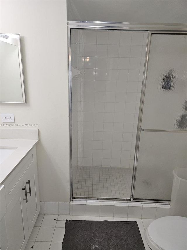 full bathroom featuring a stall shower, tile patterned flooring, vanity, and toilet