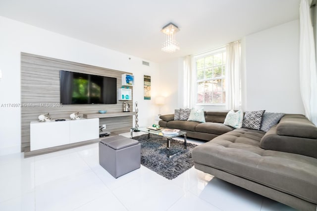 living room featuring visible vents, a notable chandelier, and light tile patterned flooring