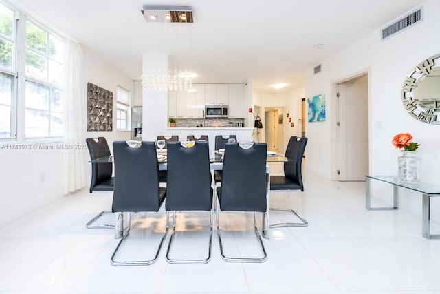 dining space with light tile patterned floors, a chandelier, and visible vents