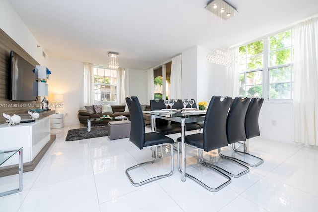 dining area featuring light tile patterned flooring and a notable chandelier