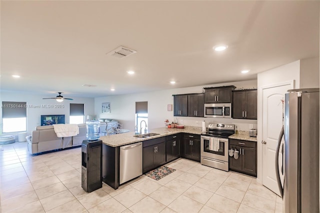 kitchen with stainless steel appliances, visible vents, open floor plan, a sink, and a peninsula