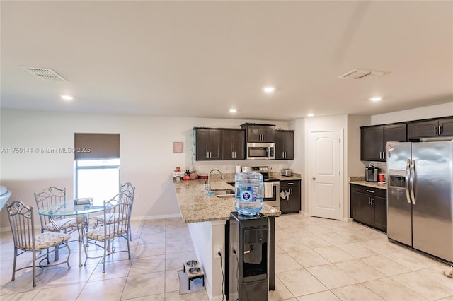 kitchen featuring stainless steel appliances, visible vents, light stone counters, and light tile patterned floors