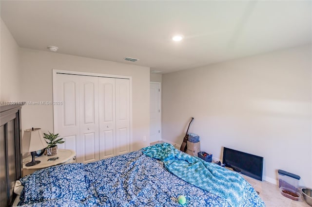 bedroom featuring light tile patterned floors, baseboards, visible vents, and a closet