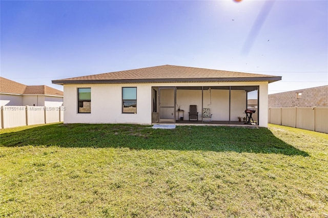 rear view of property featuring a shingled roof, a lawn, a fenced backyard, and stucco siding