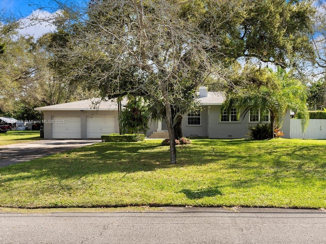 view of front of house with driveway, an attached garage, fence, a front yard, and stucco siding