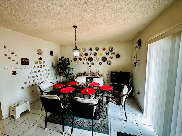 dining space featuring light tile patterned floors and a textured ceiling