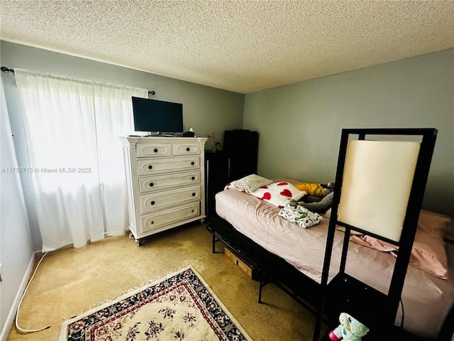 bedroom with light carpet, a textured ceiling, and baseboards