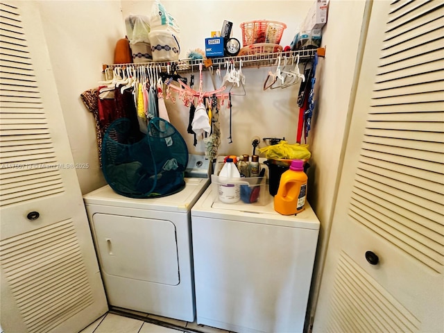 laundry area with laundry area, washing machine and dryer, and light tile patterned flooring