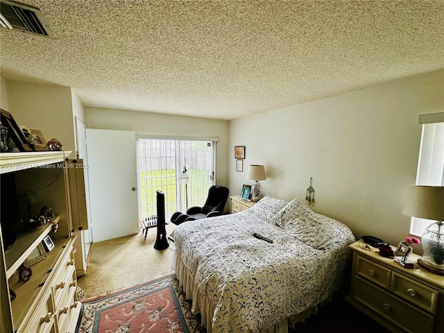 bedroom with access to exterior, visible vents, and a textured ceiling