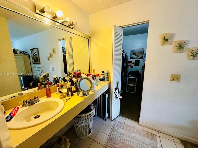 bathroom featuring a textured ceiling, tile patterned flooring, and vanity