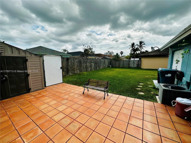 view of patio / terrace with a storage shed, a fenced backyard, and an outdoor structure