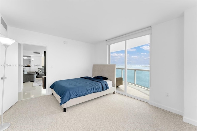 carpeted bedroom with a water view, access to outside, and baseboards