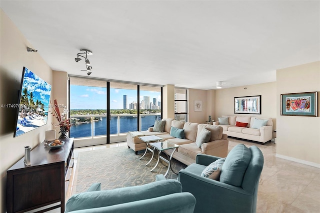 living area featuring ceiling fan, expansive windows, baseboards, and track lighting