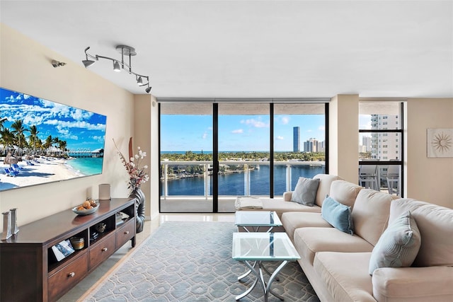 living room with rail lighting, floor to ceiling windows, and a water view