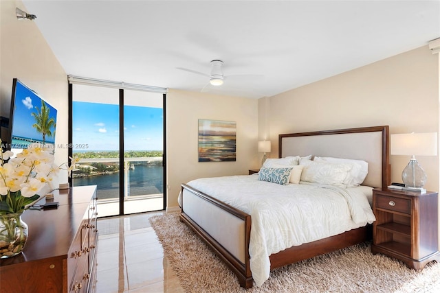 bedroom featuring access to exterior, expansive windows, and a ceiling fan