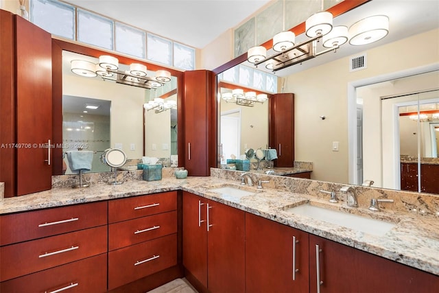 full bath featuring double vanity, visible vents, and a sink