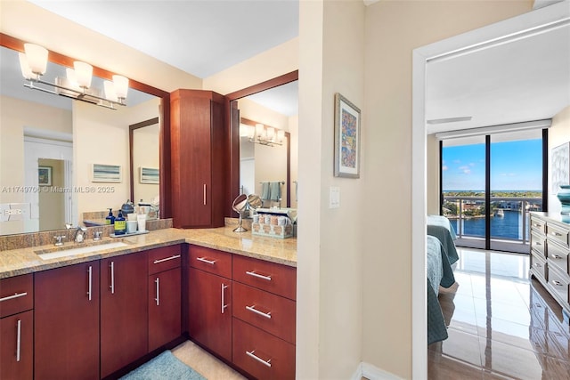 bathroom featuring a water view, expansive windows, and vanity