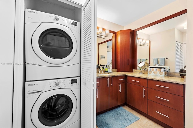 laundry area featuring a chandelier, laundry area, a sink, and stacked washer / drying machine