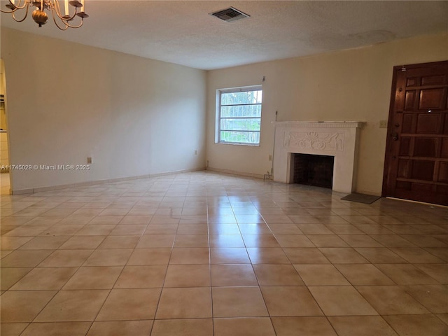 unfurnished living room featuring light tile patterned floors, visible vents, a premium fireplace, a textured ceiling, and a chandelier