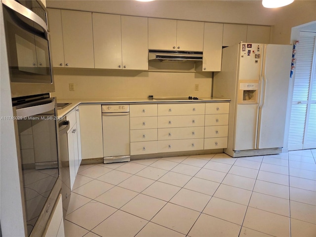 kitchen with white cabinets, stainless steel appliances, light countertops, under cabinet range hood, and light tile patterned flooring