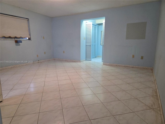 empty room featuring light tile patterned floors and baseboards