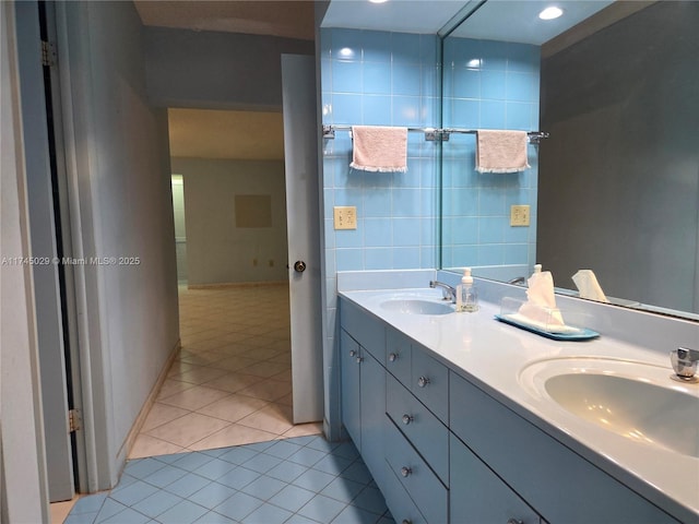 full bathroom featuring double vanity, tile patterned flooring, tile walls, and a sink