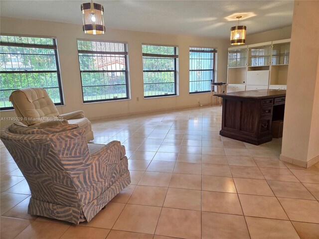 interior space featuring light tile patterned floors, baseboards, and a healthy amount of sunlight