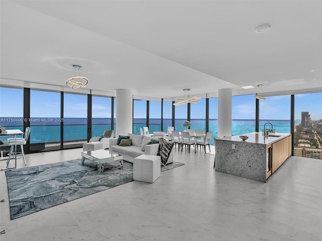 living room with expansive windows, a water view, and plenty of natural light