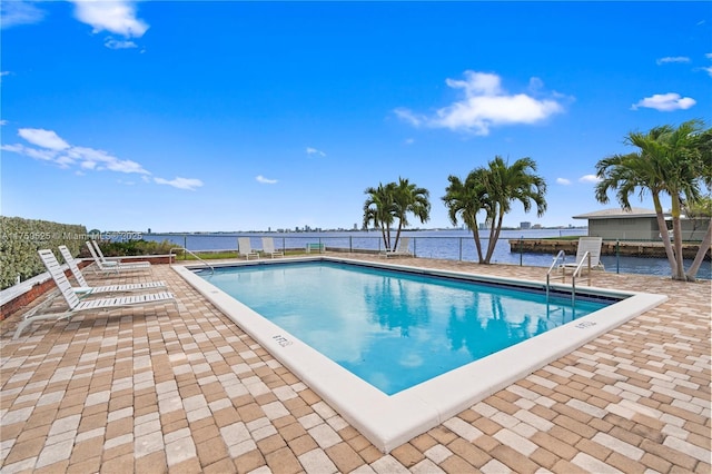 community pool with a patio and a water view