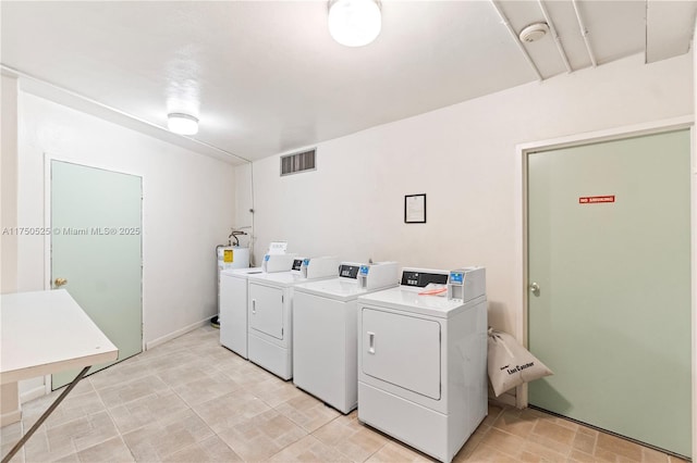 shared laundry area with washing machine and clothes dryer and visible vents