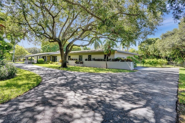 view of front of home with driveway and fence