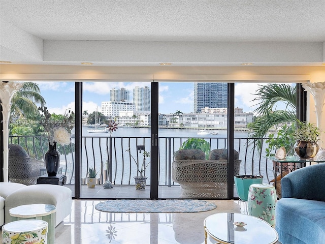 interior space featuring a water view, plenty of natural light, a city view, and a textured ceiling