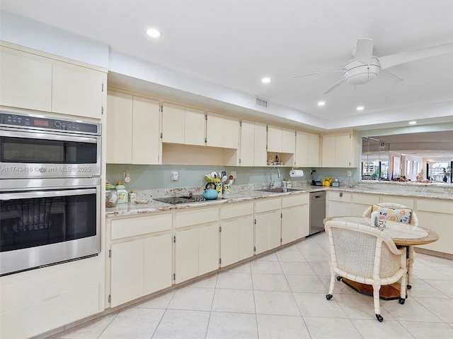 kitchen featuring cream cabinetry, stainless steel appliances, recessed lighting, visible vents, and a sink