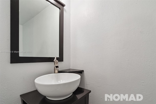 bathroom with a textured wall and vanity